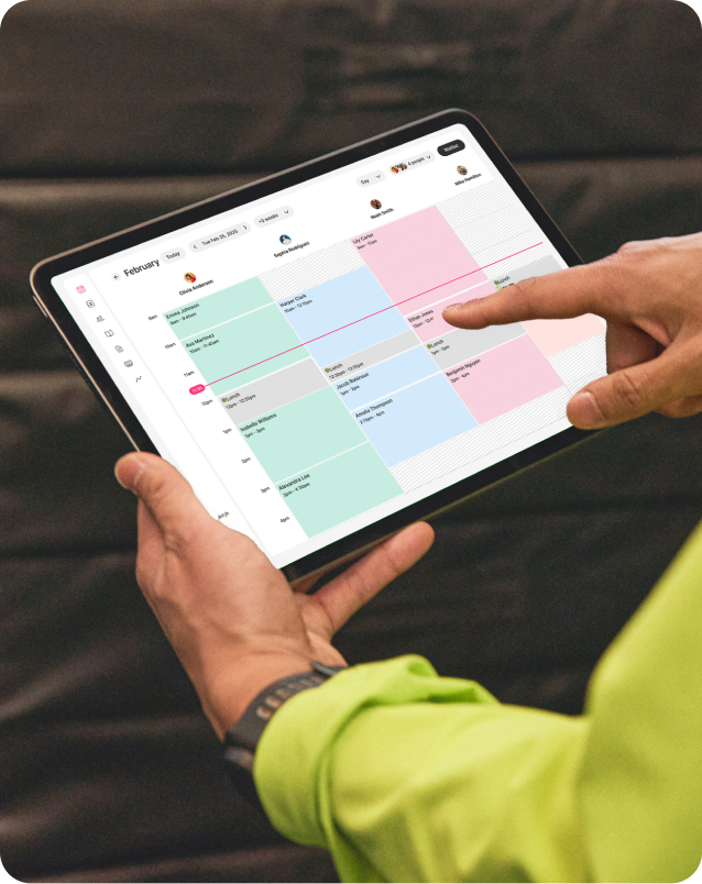 Hands holding tablet with GlossGenius calendar